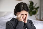 Young woman holding her hands to her temples